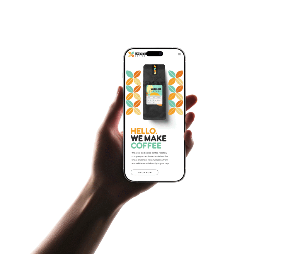 A hand holds a mobile displaying a coffee brand’s website, featuring a coffee bag, colourful geometric patterns, and the text “HELLO. WE MAKE COFFEE.” with a description and a “SHOP NOW” button.