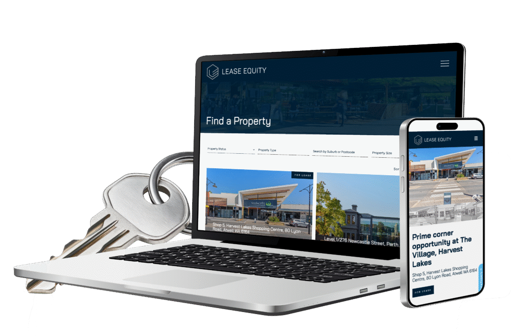 A laptop displaying a property search website sits next to a large key and a mobile phone showing the same site, suggesting online property services and listings.