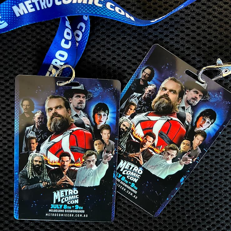 Two Metro Comic Con event passes featuring a collage of characters from various films and TV programmes, attached to blue Metro Comic Con lanyards, are displayed on a black textured surface.