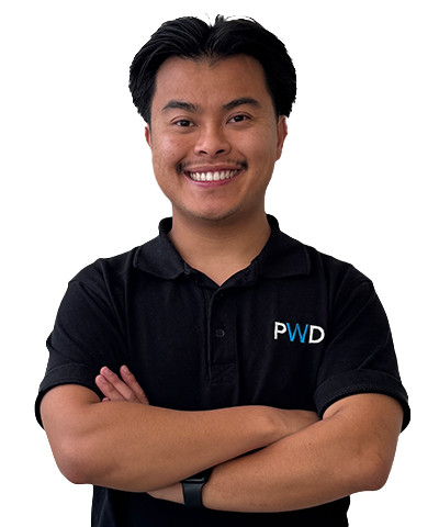 A smiling person with short dark hair, wearing a black polo shirt with the letters PWD on it, stands with arms folded against a plain white background. This is Allan Truong.