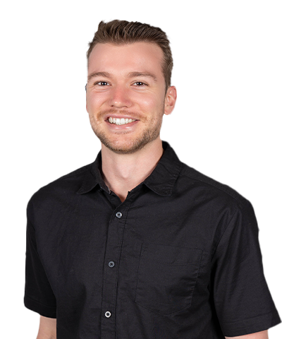 John Weckman, a smiling man with short light brown hair and a trimmed beard, wears a black short-sleeve button-up shirt as he stands against a plain light background.
