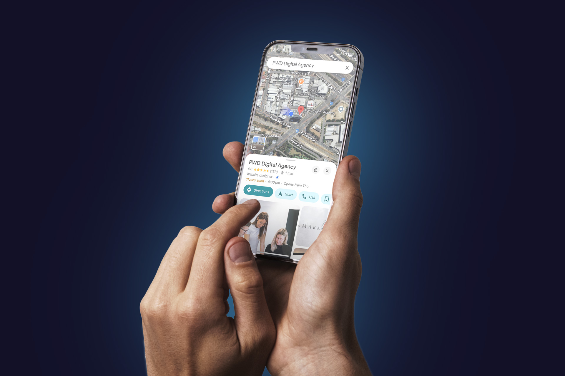 A person holds a smartphone displaying a Google My Business map with a business location marked, while their other hand points at the phone screen against a dark blue gradient background.