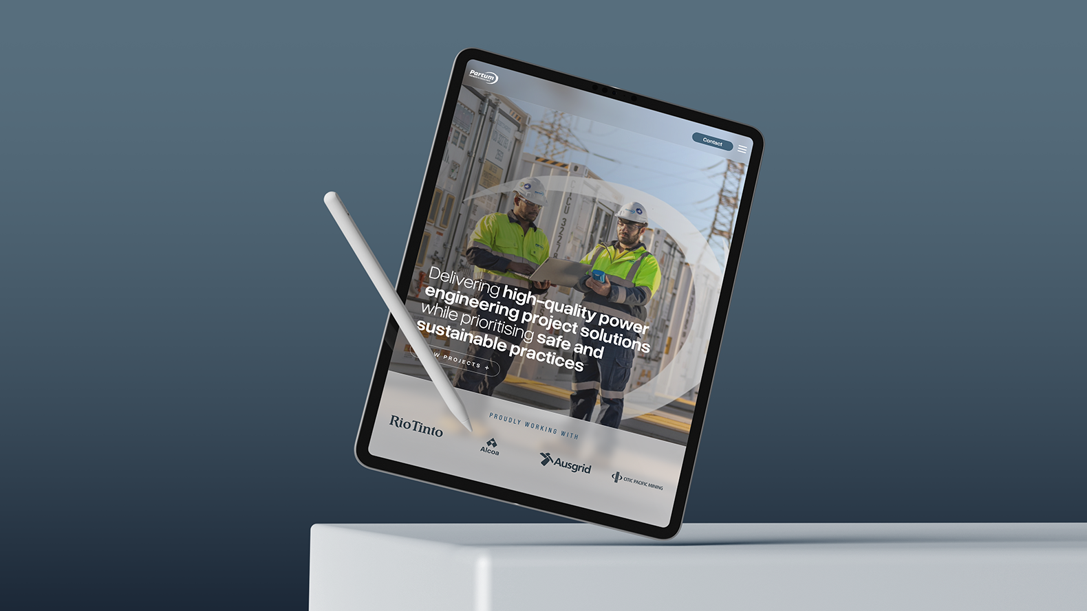 A digital tablet with a stylus displays a website for Partum Engineering, featuring two workers in safety gear near industrial equipment, with text about delivering high-quality power engineering project solutions.