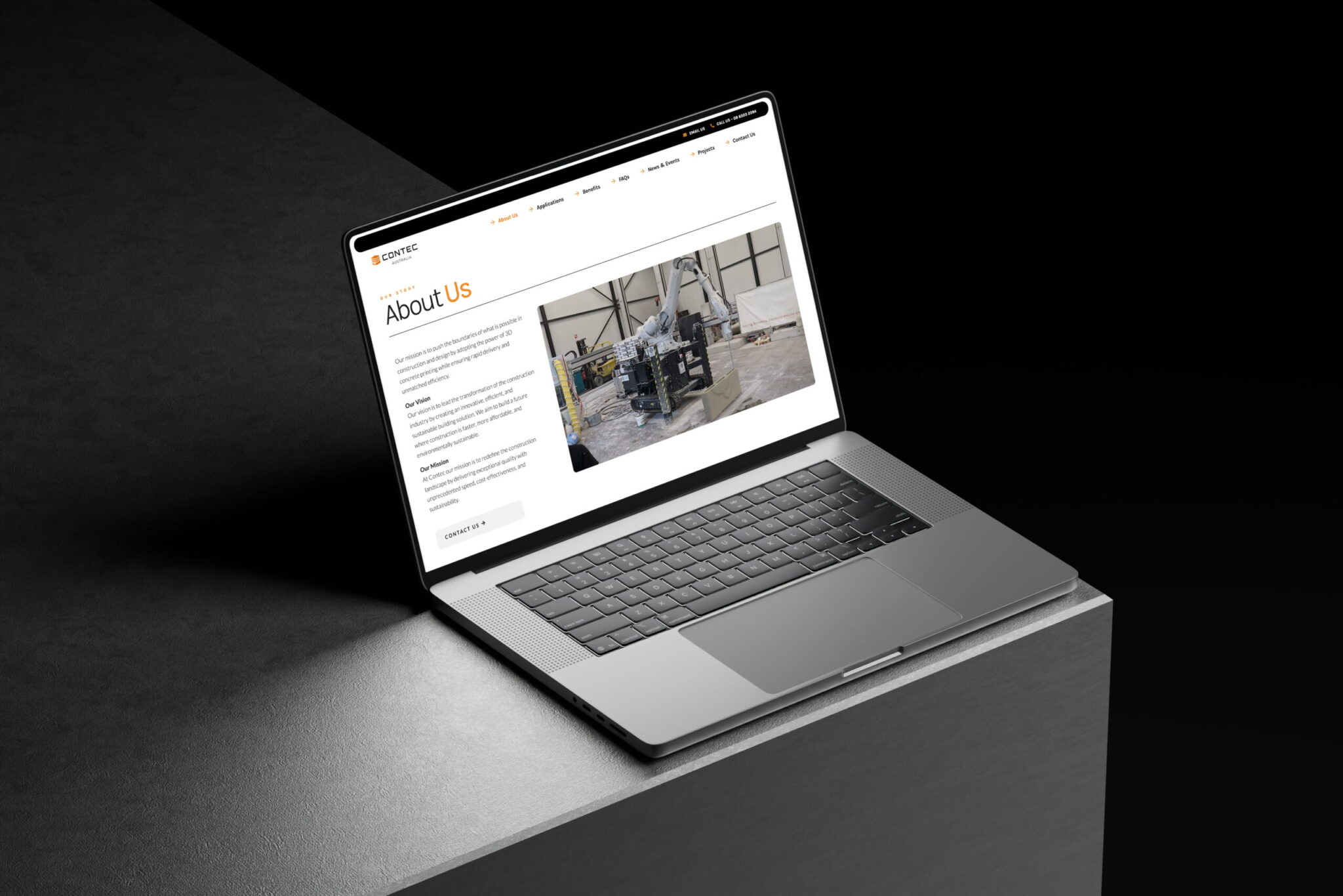 A laptop on a grey surface displays Contec Australia’s About Us page, featuring text on the left and a large industrial machine photo on the right, set against a dark background.