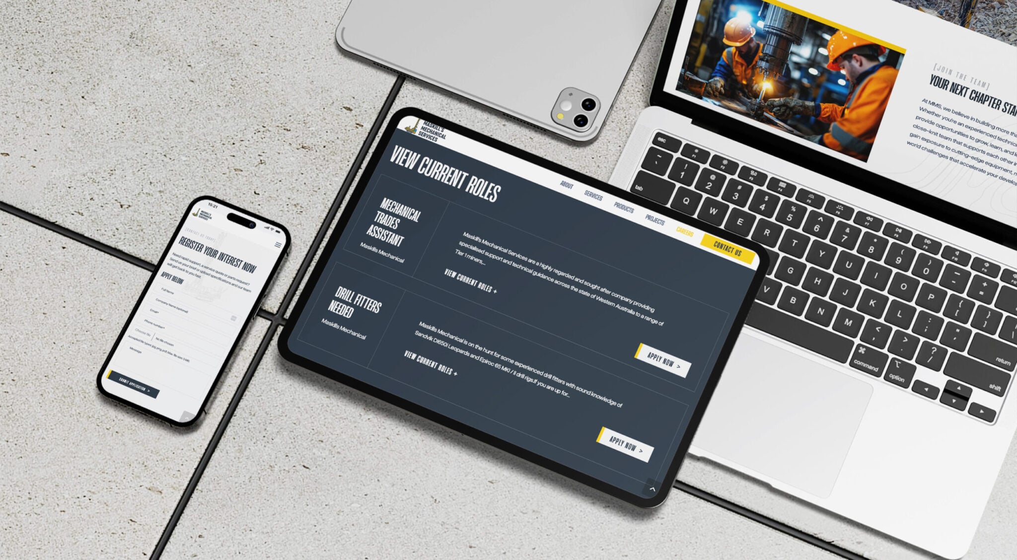 A smartphone, tablet, and laptop are displayed on a stone surface. Each device shows different web pages from the Maskills Mechanical Services website, including a job application form, current job roles, and workers in a construction-related setting.