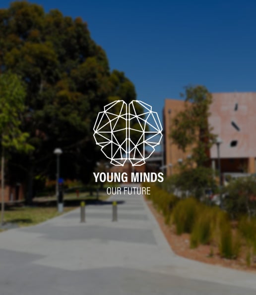A geometric brain icon and the words Young Minds, Our Future overlay a blurred outdoor campus scene with trees, buildings, and a pathway beneath a clear blue sky.