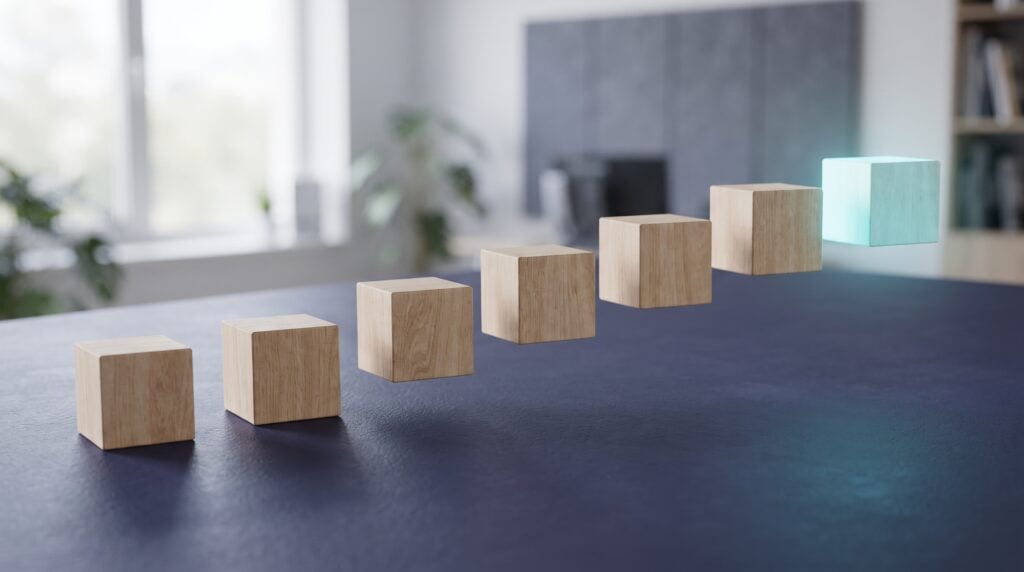 Eight plain timber blocks laid in a rising line across a dark indigo desk, the last block lit in cyan
