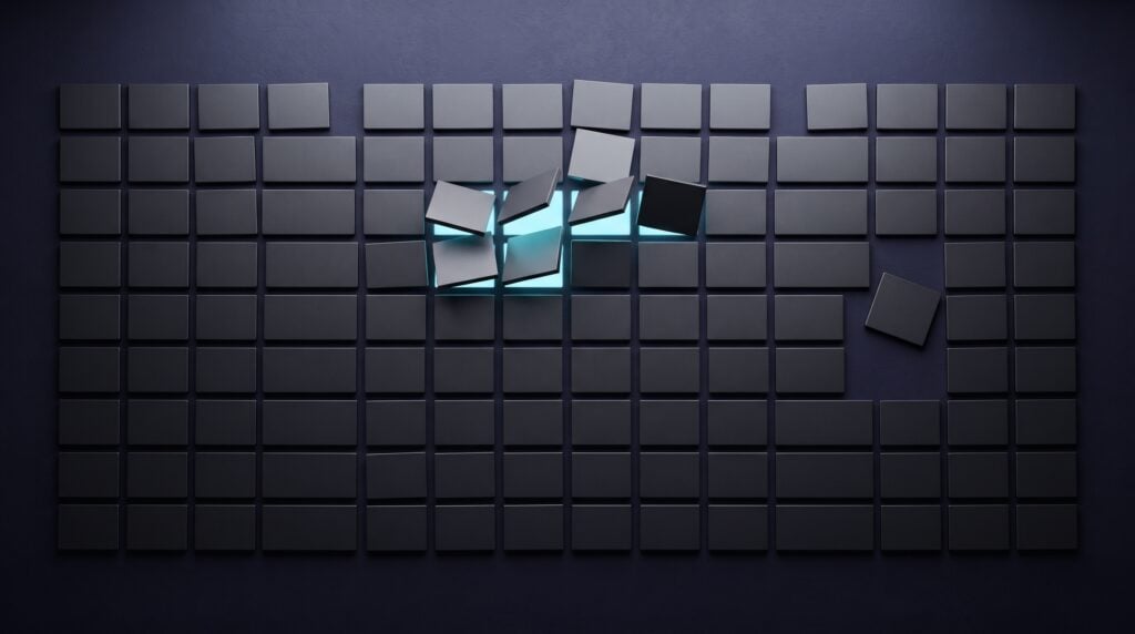 A wall of raised dark indigo tiles in a calendar grid, with a few tiles lifted and lit from beneath in cyan