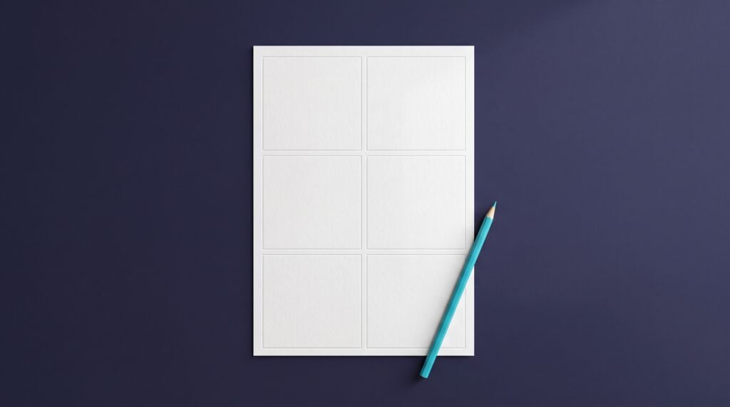 A single sheet of white paper divided into six blank panels, lying on a dark indigo desk beside a cyan pencil